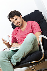 Image showing Man Sitting on Chair with Book and a Drink