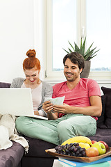 Image showing Couple at the Couch with Laptop, Card and Money