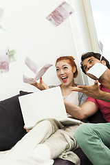 Image showing Sitting Happy Couple Throwing Money in the Air