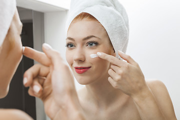 Image showing Woman After Shower Applying Cream on her Face