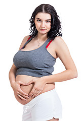 Image showing Young pregnant woman making a heart gesture