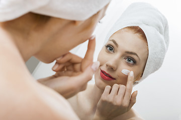 Image showing Woman After Shower Applying Cream on her Face