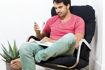 Image showing Man Sitting on Chair with Book and a Drink