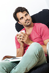 Image showing Man Sitting on Chair with Book and a Drink