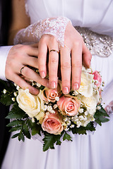Image showing Hands of the newlyweds with wedding bouquet