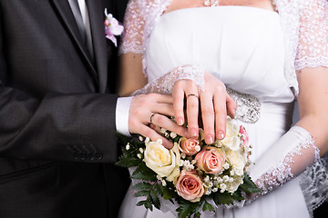 Image showing Hands of the newlyweds with wedding bouquet