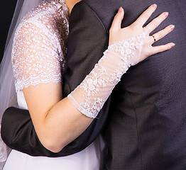 Image showing bride hand on the back of the groom. Gentle loving hug