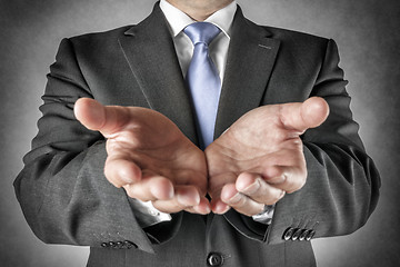 Image showing Businessman holds out hands