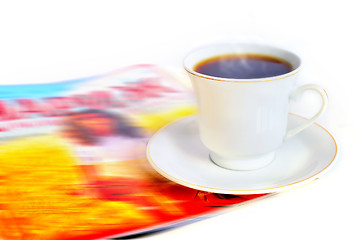 Image showing A cup of hot coffee and a magazine 