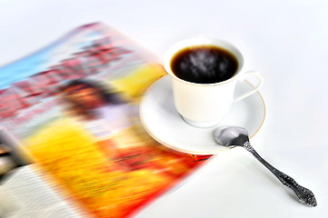 Image showing A cup of hot coffee and a magazine 