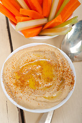 Image showing fresh hummus dip with raw carrot and celery 