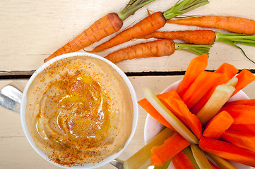 Image showing fresh hummus dip with raw carrot and celery 