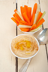 Image showing fresh hummus dip with raw carrot and celery 