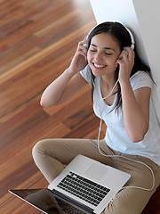 Image showing relaxed young woman at home working on laptop computer