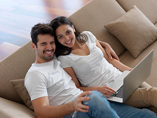 Image showing relaxed young couple working on laptop computer at home