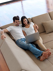 Image showing relaxed young couple working on laptop computer at home