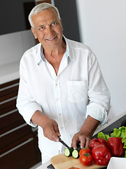 Image showing man cooking at home preparing salad in kitchen