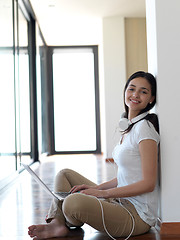 Image showing relaxed young woman at home working on laptop computer