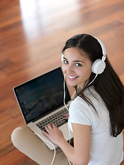 Image showing relaxed young woman at home working on laptop computer