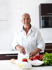 Image showing man cooking at home preparing salad in kitchen