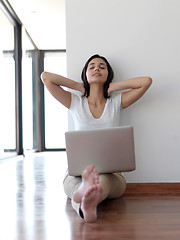 Image showing relaxed young woman at home working on laptop computer