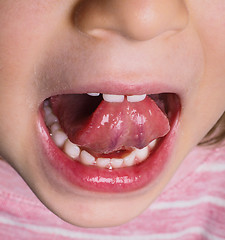 Image showing Little girl with pink shirt protruding tongue backwards with man