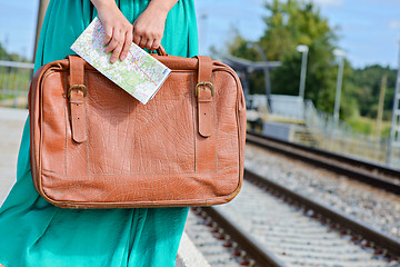 Image showing Womans hands holding a map and suitcase at station