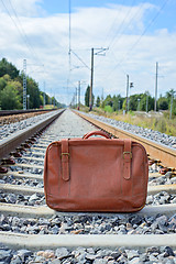 Image showing Vintage brown suitcase on the railway