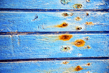 Image showing dirty stripped   in the blue  door and rusty  