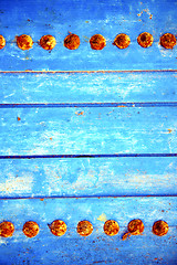 Image showing dirty stripped paint in   blue wood door and rusty 