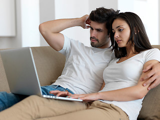 Image showing relaxed young couple working on laptop computer at home