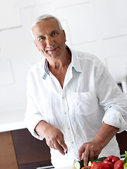 Image showing man cooking at home preparing salad in kitchen