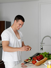 Image showing man cooking at home preparing salad in kitchen