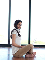 Image showing relaxed young woman at home working on laptop computer