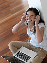 Image showing relaxed young woman at home working on laptop computer