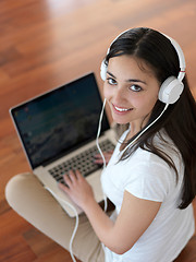 Image showing relaxed young woman at home working on laptop computer