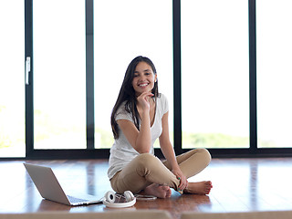 Image showing relaxed young woman at home working on laptop computer