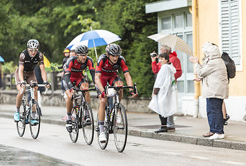 Image showing Three Cyclists Riding in the Rain