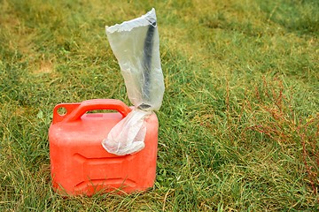 Image showing Red jerrycan on green grass