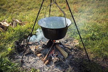 Image showing Camp fire outdoors burning with pot