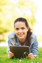 Image showing smiling young girl tablet pc lying on grass
