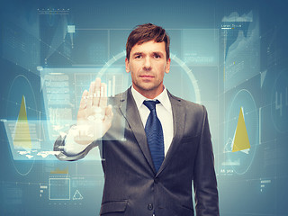 Image showing attractive buisnessman wotking with virtual screen