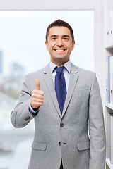 Image showing happy businessman showing thumbs up in office