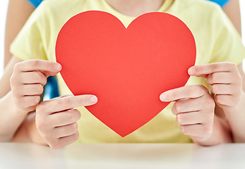 Image showing close up of girl and mother holding red heart