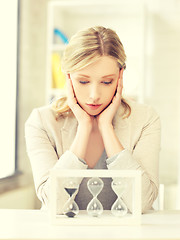 Image showing pensive businesswoman with sand glass