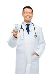 Image showing smiling male doctor in white coat with tablets