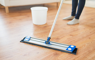 Image showing close up of woman with mop cleaning floor at home