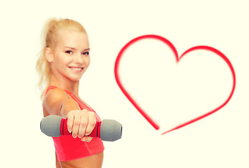 Image showing smiling beautiful sporty woman with dumbbell