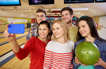 Image showing happy friends with smartphone in bowling club