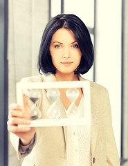 Image showing pensive businesswoman with sand glass